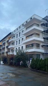 a large white apartment building with a parking lot at Milano Apartment in Hamburg