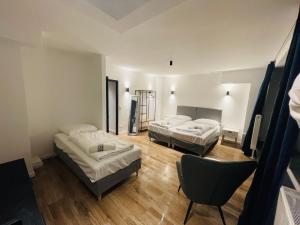 a room with two beds and a chair in it at Milano Apartment in Hamburg