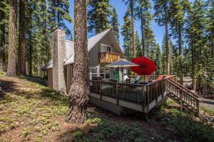 a house with a deck with a table and an umbrella at Hillhouse By Hauserman Rentals in Homewood