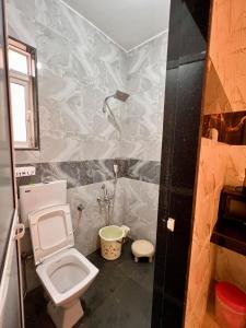 a small bathroom with a toilet and a shower at Sugar Waves in Navi Mumbai