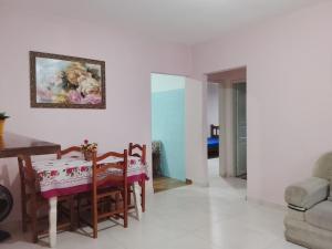 a dining room with a table and chairs and a painting on the wall at Casa da vovó Marta in Itanhaém