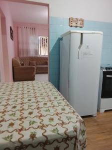 a room with a refrigerator and a living room at Casa da vovó Marta in Itanhaém