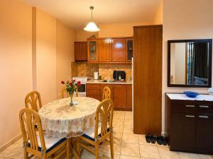 a kitchen with a table with a vase of flowers on it at Lana's Apartment in Sarandë