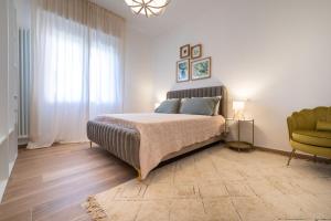 a bedroom with a bed and a green chair at Casa MaMi in Gatteo a Mare
