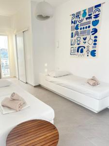 two beds in a room with a painting on the wall at Daphne in Naousa