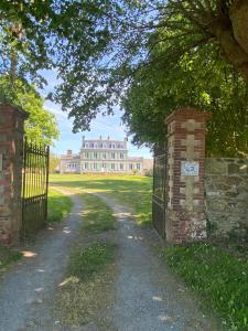 an entrance to a large house with a gate at La Maison du Hommeel in Gratot