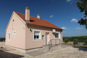 a small white house with a red roof at Potkova in Lađevci