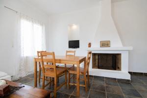 a dining room with a table and chairs and a fireplace at Mylopota apartment IV in Ios Chora