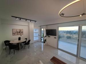 a dining room with a table and a large window at Hanna's Villagio in Korinthos