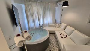 a white bathroom with a tub and a couch at Eveline 2 - Piscina Privata o Jacuzzi in Sanremo +56 photos