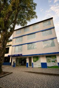 a building with a tree in front of it at Hotel Arboleda de Cádiz in Ibagué +16 photos