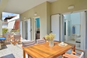 a dining room with a wooden table and chairs at Vottas Seaside House Nea Makri in Nea Makri