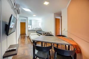 a room with a table and chairs and a living room at Lofty Departamentos Temporarios in Córdoba