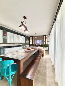 a dining room with a large wooden table and blue chairs at Quarto 5J Joinville Costa e Silva perto Centro in Joinville