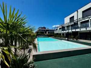 a swimming pool in front of a building at Grey Lights Garden Apartment in Siófok
