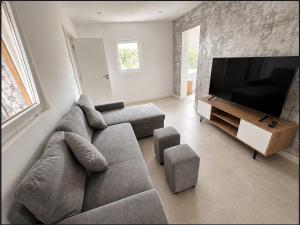 ein Wohnzimmer mit Sofa und Flachbildfernseher in der Unterkunft PineHills in Torres Vedras