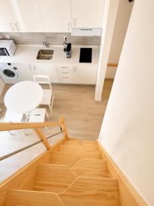 a room with a wooden floor and a white table at Casa do Leme in Nazaré +3 photos
