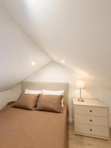 a bedroom with a bed and a dresser with a lamp at Casa do Leme in Nazaré
