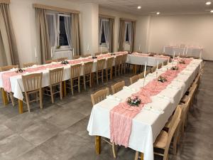 a row of tables in a room with flowers on them at hotel Manětín in Manětín +14 photos