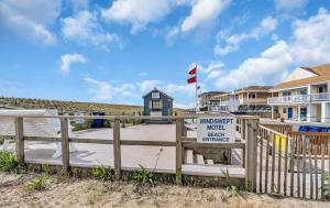 a house on the beach with a sign on a fence at Windswept Motel in Point Pleasant Beach +4 photos