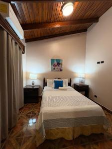 a bedroom with a large bed with blue pillows at Hostal Marias in Copán Ruinas