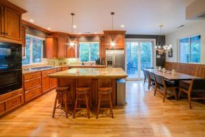 a kitchen with wooden cabinets and a large island with bar stools at Flatlanders Retreat in Twain Harte