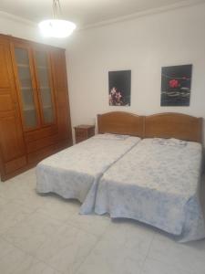 a bedroom with a large bed with a wooden headboard at O marco da legua&camino de santiago in Piñor