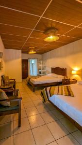 a bedroom with two beds and a wooden ceiling at Cien Fuegos Hostel in Salcoatitán