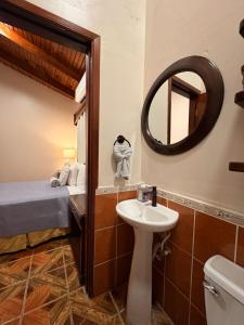 a bathroom with a sink and a mirror and a bed at Hostal Marias in Copán Ruinas +59 photos