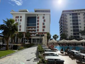 a hotel with tables and chairs next to a pool at Shengjin Apartment in Lezhë