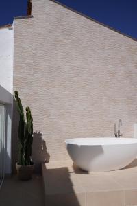 a bathroom with a white sink next to a cactus at La joya de la Alcazaba in Jerez de los Caballeros +59 photos