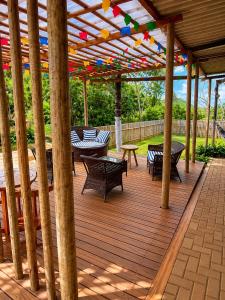 a wooden deck with tables and chairs under a pergola at Shalon Adonai by Martinelli Lodge in Fernando de Noronha