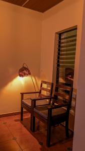 a room with two chairs and a table and a lamp at Cien Fuegos Hostel in Salcoatitán +8 photos