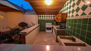 a kitchen with green and white tiles and a stove at Cien Fuegos Hostel in Salcoatitán