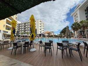 a swimming pool with tables and chairs next to a resort at Shengjin Apartment in Lezhë