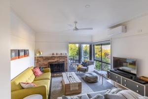 a living room with a couch and a fireplace at Hillhouse in Myrtleford