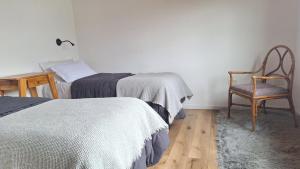 a bedroom with two beds and a chair and a chair at Jardín de Estepa in Dina Huapi