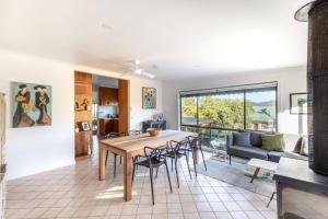a dining room and living room with a table and chairs at Hillhouse in Myrtleford +15 photos