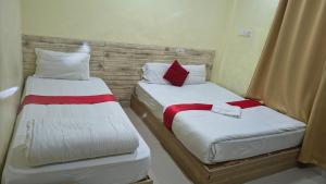 two beds sitting next to each other in a room at Kutumba home in Bhairāhawā