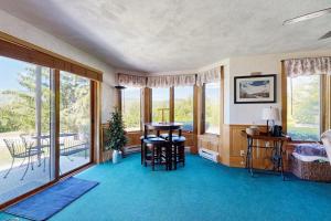 a living room with a table and chairs and windows at Christmas Mountain Retreat in Bartlett