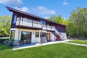a house with a balcony and a lawn at Christmas Mountain Retreat in Bartlett