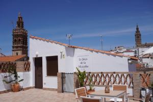 a white building with a table and chairs in front of it at La joya de la Alcazaba in Jerez de los Caballeros