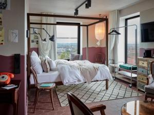 a bedroom with a bed and a large window at 25hours Hotel Das Tour in Düsseldorf