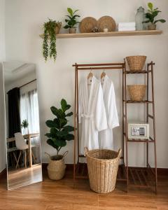 a room with a rack with white robes and a mirror at Nami by Secret Place in Mae Haad