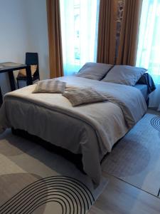 a large bed with pillows on it in a bedroom at TINCHEBRAY Centre ville in Tinchebray