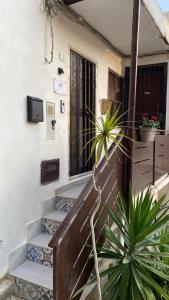 a house with stairs leading to a door with a plant at ANTICO VICOLO in Agrigento