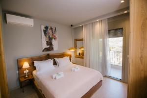 a bedroom with a bed with two towels on it at Maresol Villa in Nea Kallikrateia