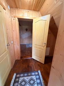 an attic room with a door and a rug at Садиба у Оксанки in Vorokhta