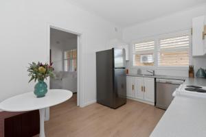 a kitchen with a vase of flowers on a table at Oak and Olive - Glenelg in Glenelg
