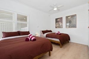 a bedroom with two beds with pink bows on them at Oak and Olive - Glenelg in Glenelg